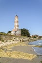 Lighthouse from the beach with seaweeds and waves breaker Royalty Free Stock Photo