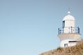 Lighthouse behind a hill against a blue sky in Port Macquarie beach in Australia Royalty Free Stock Photo