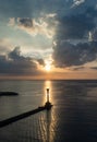 Lighthouse and a boat over the calm sea on sunset Royalty Free Stock Photo