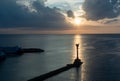 Lighthouse and a boat over the calm sea on sunset Royalty Free Stock Photo