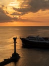 Lighthouse and a boat over the calm sea on sunset Royalty Free Stock Photo