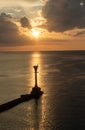 Lighthouse and a boat over the calm sea on sunset Royalty Free Stock Photo