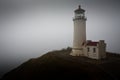 Lighthouse on cliff above a fog covered ocean