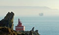 Lighthouse in the coast with freighter in Galicia, Spain, Europe. Royalty Free Stock Photo