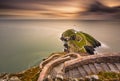 Lighthouse on coastal island with horizon and beautiful sunset Royalty Free Stock Photo
