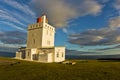 Lighthouse at Dyrholaey rock at sunset with dramatic sky