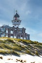 The lighthouse of Egmond aan Zee, Netherlands, behind new buildings and the beach dune in front Royalty Free Stock Photo