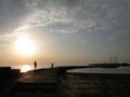 Lighthouse at the end of the pier of stones, sunset over the Adriatic Sea, Croatia, Europe.Orange, calm sea, silhouette, reflectio Royalty Free Stock Photo