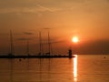 Lighthouse at the end of the pier of stones, sunset over the Adriatic Sea, Croatia, Europe.Orange, calm sea, silhouette, reflectio Royalty Free Stock Photo