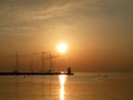 Lighthouse at the end of the pier of stones, sunset over the Adriatic Sea, Croatia, Europe.Orange, calm sea, silhouette, reflectio Royalty Free Stock Photo