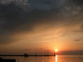 Lighthouse at the end of the pier of stones, sunset over the Adriatic Sea, Croatia, Europe.Orange, calm sea, silhouette, reflectio Royalty Free Stock Photo