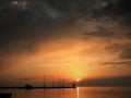 Lighthouse at the end of the pier of stones, sunset over the Adriatic Sea, Croatia, Europe.Orange, calm sea, silhouette, reflectio Royalty Free Stock Photo