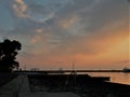 Lighthouse at the end of the pier of stones, sunset over the Adriatic Sea, Croatia, Europe.Orange, calm sea, silhouette, reflectio