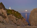 Lighthouse Far de capdepera, dusk, moonbeam on sea,rocks and trees, cala ratjada, mallorca, spain Royalty Free Stock Photo
