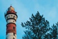 Lighthouse in the forest among the trees. red and white lighthouse Royalty Free Stock Photo