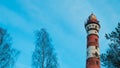 Lighthouse in the forest among the trees. red and white lighthouse Royalty Free Stock Photo