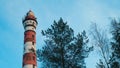 Lighthouse in the forest among the trees. red and white lighthouse Royalty Free Stock Photo