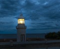 Lighthouse Glowing At Dark Night On Coast