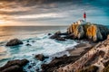 Lighthouse on a grassy cliff with a sunset sky and a blue ocean Royalty Free Stock Photo