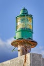 Lighthouse green beacon against blue sky
