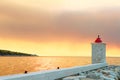 Lighthouse in the harbor of town Postira shot at sunset - Croatia, island Brac Royalty Free Stock Photo