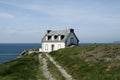Lighthouse house with green lawn and blue ocean. Brittany, France