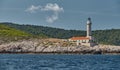 The lighthouse on the island in Croatia nearby Vis at sunset, a rocky coast, ladder to a beacon, a small cape Royalty Free Stock Photo