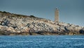 The lighthouse on the island in Croatia nearby Vis at sunset, a rocky coast, ladder to a beacon, a small cape Royalty Free Stock Photo