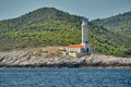 The lighthouse on the island in Croatia nearby Vis at sunset, a rocky coast, ladder to a beacon, a small cape Royalty Free Stock Photo