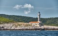 The lighthouse on the island in Croatia nearby Vis at sunset, a rocky coast, ladder to a beacon, a small cape Royalty Free Stock Photo