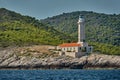 The lighthouse on the island in Croatia nearby Vis at sunset, a rocky coast, ladder to a beacon, a small cape Royalty Free Stock Photo