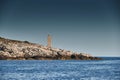The lighthouse on the island in Croatia nearby Vis at sunset, a rocky coast, ladder to a beacon, a small cape Royalty Free Stock Photo