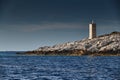 The lighthouse on the island in Croatia nearby Vis at sunset, a rocky coast, ladder to a beacon, a small cape Royalty Free Stock Photo