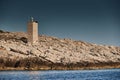 The lighthouse on the island in Croatia nearby Vis at sunset, a rocky coast, ladder to a beacon, a small cape Royalty Free Stock Photo