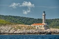 The lighthouse on the island in Croatia nearby Vis at sunset, a rocky coast, ladder to a beacon, a small cape Royalty Free Stock Photo