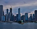 Lighthouse juts into Lake Michigan with marina of sailboats on left, loch on right, and skyline of Chicago with evening sunset in Royalty Free Stock Photo