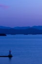 Lighthouse on Lake Champlain at dusk with Adirondack mountains in background Royalty Free Stock Photo