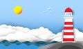 The lighthouse is located in the rocks by the sea with clouds in the sky and the sun.