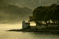 Lighthouse in misty yellow morning