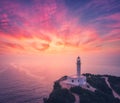 Lighthouse on the mountain peak at colorful sunset in summer Royalty Free Stock Photo