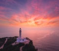 Lighthouse on the mountain peak at colorful sunset in summer