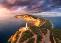 Lighthouse on the mountain peak at colorful sunset in summer