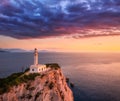 Lighthouse on the mountain peak at colorful sunset in summer
