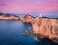 Lighthouse on the mountain peak at colorful sunset in summer