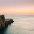 Lighthouse at Neist Point, Isle of Skye, beautiful sunset with cliffs, mountains and islands Royalty Free Stock Photo