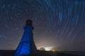 Stars trails at lighthouse. Night landscape.