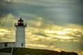 lighthouse Nubble against a dramatic sky background with sun rays and birds in the sky. USA. Maine.