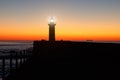 Lighthouse On The Ocean, Silhouette At Sunset.