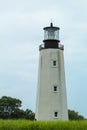 A lighthouse in a patch of bright green grass near Cape Henlopen, Delaware Royalty Free Stock Photo