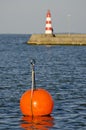 Lighthouse on pier and red buoy Royalty Free Stock Photo